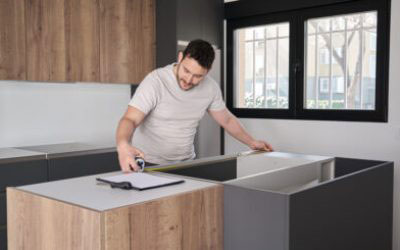 The image features a man standing at a kitchen counter with white cabinets, preparing to write on a piece of paper using a pen.